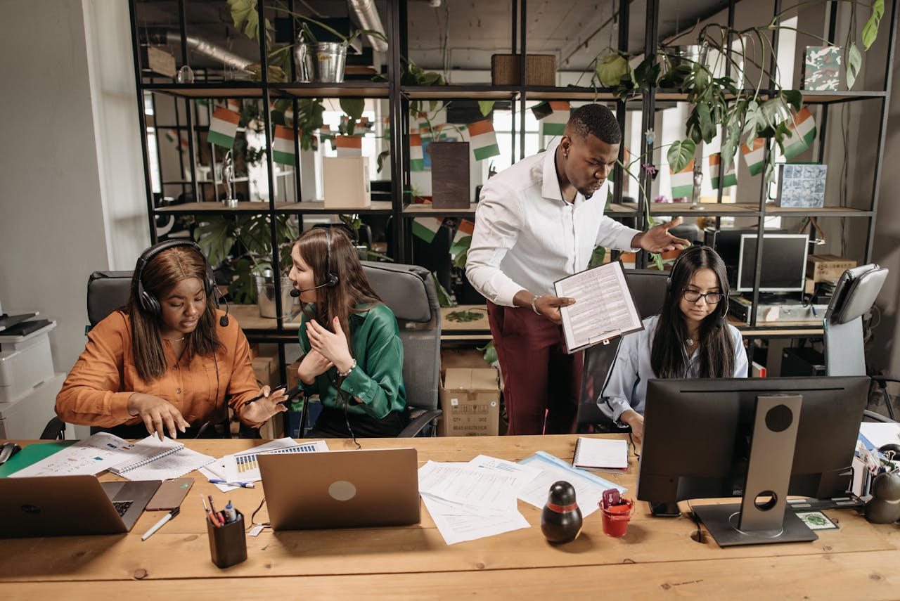 A diverse team of call center agents in a lively office setting, collaborating on tasks and discussing reports.