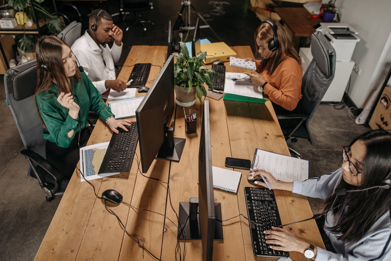 Diverse team of customer service representatives working collaboratively in a modern office environment.